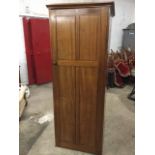 An Edwardian mahogany wardrobe of panelled construction, the interior with shelf and hanging