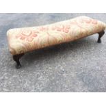 A long upholstered stool with brass studding, raised on stub cabriole legs. (39in)