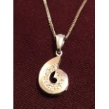 A 9ct white gold diamond pendant, the ten pave set diamonds within a gold swirl, mounted on a fine