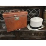 An Edwardian leather cased top hat by Harrods, size 7.25, the lined case with chromed mounts.