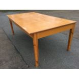 A rectangular worktable with composition top on pine square tapering legs. (48in x 88.5in x 32.