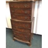A reproduction bowfronted miniature walnut tall boy, the seven drawers mounted with brass pierced