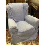 An upholstered wing armchair with loose covers, having padded back and arms above a sprung seat,