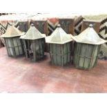 A set of four arts & crafts style wrought iron wall lights, modelled as hexagonal lanterns with