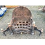 An Adams style fire grate with brass urn finials to columns on paw feet, the rectangular basket with