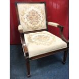 A Georgian style library armchair with floral brussels tapestry back and seat in channelled frames