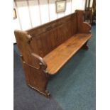 A Victorian pitch pine pew, with tongue & groove boarded back above a bench seat, the shaped