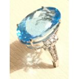 An 18ct gold topaz and diamond ring, the large claw set blue topaz weighing over nineteen carats,