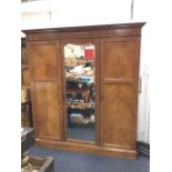 An Edwardian walnut combination wardrobe with moulded cornice above chequered inlaid frieze,