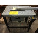 A saw bench with adjustable rip saw on rectangular rounded table, complete with ruled cutting