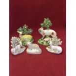 A pair of nineteenth century porcelain seated deer in front of floral bocage; a Victorian polychrome