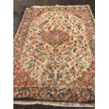 A Wilton style carpet woven with field of foliage on fawn ground around a circular floral medallion,