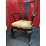 A nineteenth century Queen Anne style armchair, the back with vase shaped splat beneath arched rail,