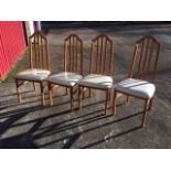 A set of four Caxton dining chairs, the arched backs enclosing slats above upholstered seats, raised