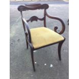 A regency mahogany elbow chair, the carved back rail above scrolled arms joined by shell carved