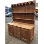 A nineteenth century pine dresser, the delft rack with rippled apron having shaped sides framing