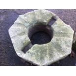 An octagonal sandstone block from a nineteenth century mill, having circular central aperture. (26in