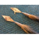 A pair of 5ft tribal spears, the ebonised wood shafts with chisel carvings, the wrought iron diamond