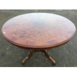 A circular burr walnut breakfast table, the crossbanded moulded top with scalloped apron raised on