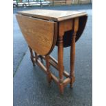 An oval oak gateleg table, the top with two drop leaves supported on hinged gates, raised on