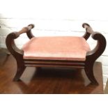 A nineteenth century mahogany footstool, the rectangular upholstered seat panel flanked by turned