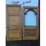 Two wide pine doors, one with arched glazed panel, the other with three rectangular panels, both
