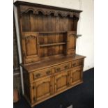 A Georgian style oak dresser, the delft rack with dentil cornice above a pierced waved apron, having