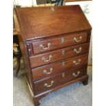 A small Georgian mahogany bureau, the cleated fallfront enclosing a fitted interior with small