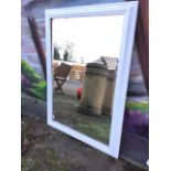 A painted cushion framed mirror with bevelled plate.