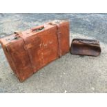 An Edwardian leather suitcase with brass studding and chromed locks, fitted with straps & buckles;