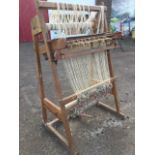 A Dryad carpet loom, the angled pine stand with ratchet rollers, sprung shuttles, etc., with