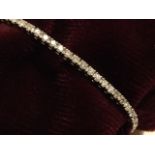 An 18ct gold diamond tennis bracelet, the individually claw set hinged stones weighing nearly