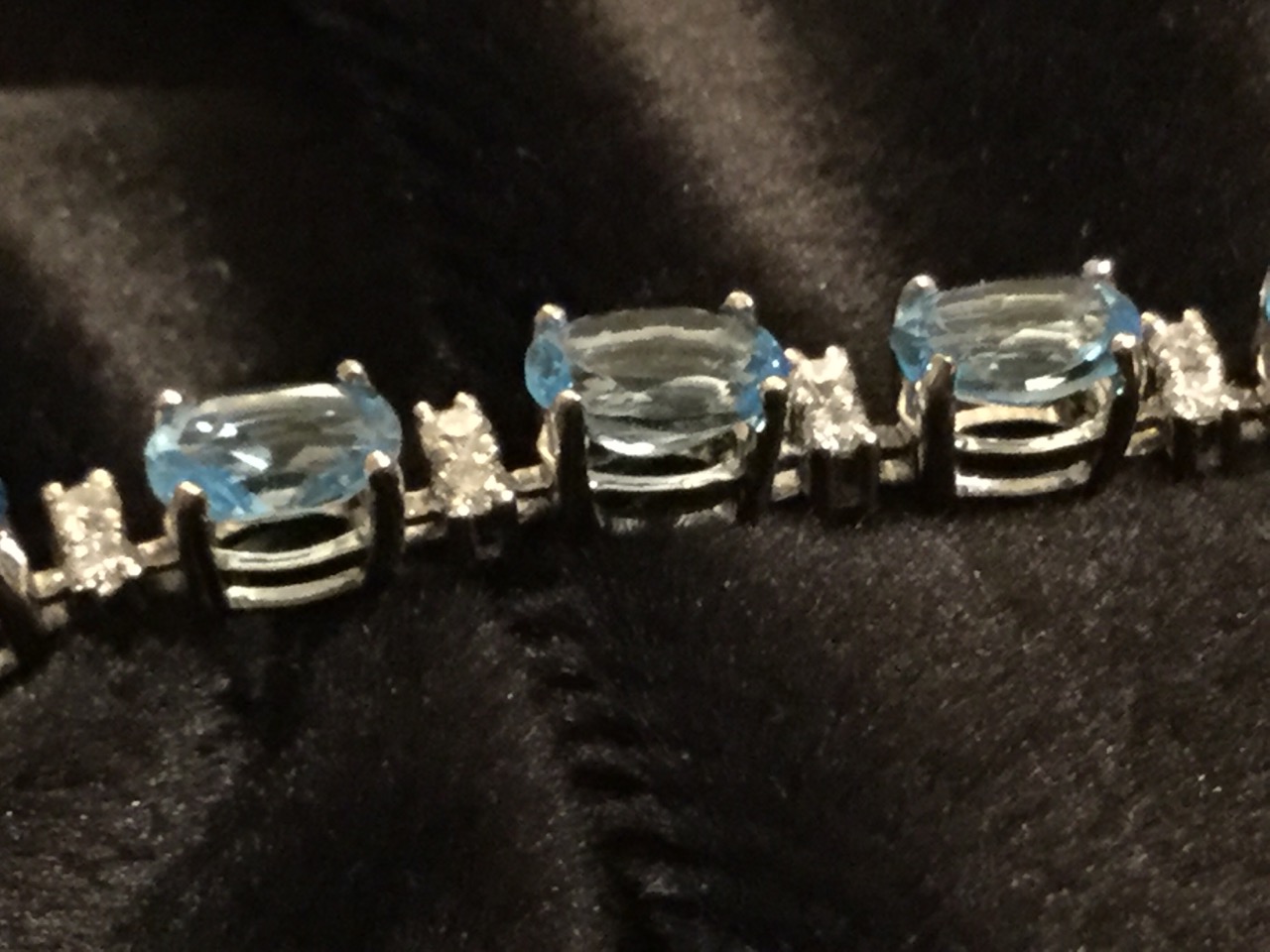 An 18ct gold blue topaz and diamond bracelet, with twenty one claw set topaz stones weighing - Image 2 of 3