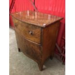 A nineteenth century bowfronted cabinet with deep drawer above a closed compartment, having shaped