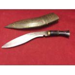 A kukri knife having scrolled decoration to curved steel blade, the horn handle with brass mounts,