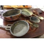 A pair of ancient copper pans with iron handles; two other copper pans; a graduated set of five