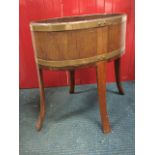 A nineteenth century oval mahogany flower tub of barrel construction with brass bandings, raised