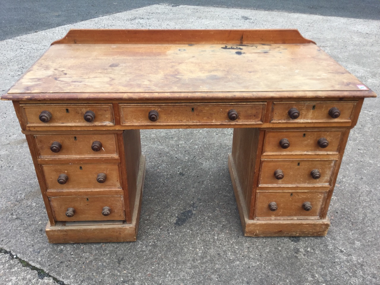 A Victorian pine kneehole desk, the rectangular moulded top with three panelled frieze drawers on