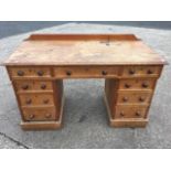 A Victorian pine kneehole desk, the rectangular moulded top with three panelled frieze drawers on