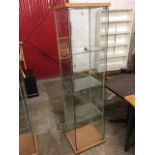 A rectangular glass display cabinet with three interior glazed shelves, the beech top with