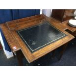 A Victorian oak writing desk with gilt tooled leather lined sliding top revealing a stationary