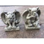 A pair of composition stone gryphons, the winged clawed beasts on rectangular plinths. (2)