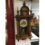 An arts & crafts Vienna style mahogany wallclock, the arched crest and pilasters decorated with
