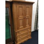 A Victorian style pine press with moulded cornice above panelled doors enclosing hanging space,
