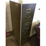 A four drawer metal filing cabinet with brass label holders and tubular handles.