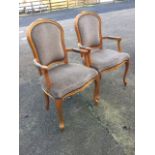 A pair of carved fauteuils with shield shaped studded upholstered backs in channel moulded frames,