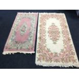 A thick pile rectangular rug woven with oval floral medallion and border on pink ground; and a