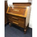 An oak bureau with panelled fallfront enclosing an interior with pigeonholes, above two long