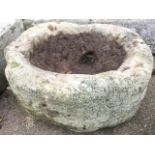 An ancient oval sandstone basin or quern with side drain. (18in x 15.5in)