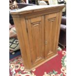 A nineteenth century pine corner cabinet with moulded cornice above a pair of panelled doors with